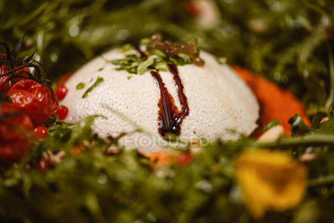 Close up view of yummy burrata cheese on cold tomato cream with arugula leaves and cherry tomatoes with truffles and peanuts — Stock Photo