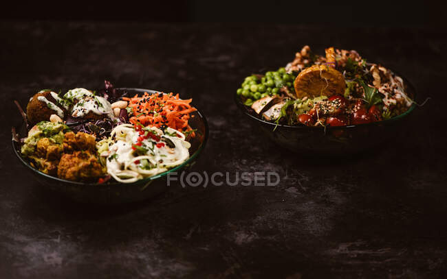 Appetizing organic vegetarian dishes with assorted vegetables on rustic dark table — Stock Photo