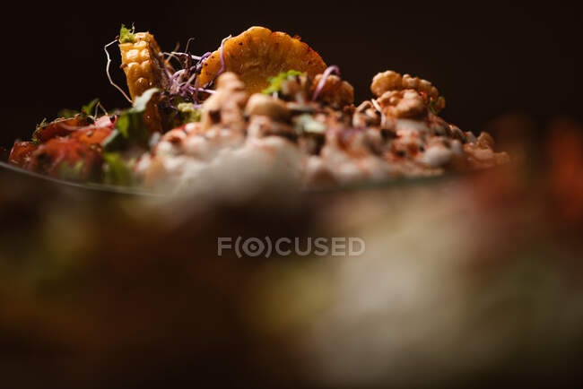 Schüssel mit leckeren Süßkartoffelscheiben mit Kirschtomaten in der Nähe von grünen Erbsen und Sesam auf dunklem Hintergrund — Stockfoto