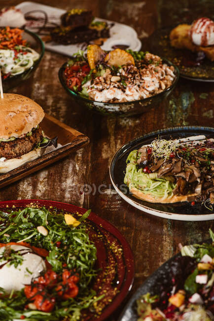 Antipasti vegetariani con funghi saltati e verdure vicino hamburger e gelato con toast alla francese sul tavolo di legno — Foto stock
