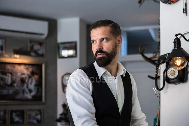 Adult brutal male executive in formal wear looking away in hairdressing salon — Fotografia de Stock