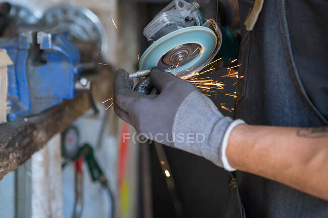 Crop meccanico maschile in guanti riparazione bicicletta in officina moderna — Foto stock