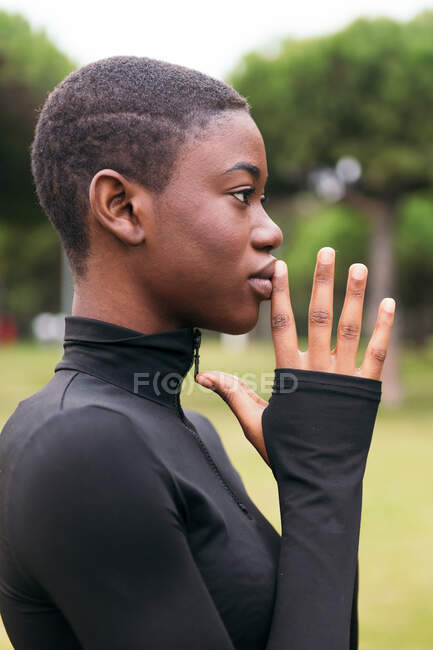 Jeune femme ethnique tendre en vêtements noirs aux cheveux courts en été — Photo de stock