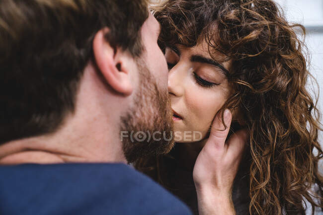 Молодой человек и женщина целуются и обнимаются, проводя романтический день вместе — стоковое фото