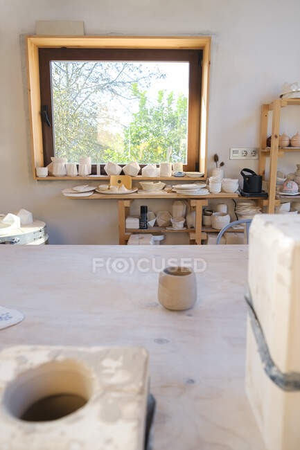 Чаша из глины, поставленная на стол в мастерской керамики — стоковое фото