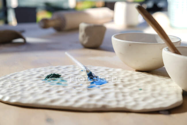 Clay bowls and ceramic object with brush for working in professional pottery workshop — Foto stock