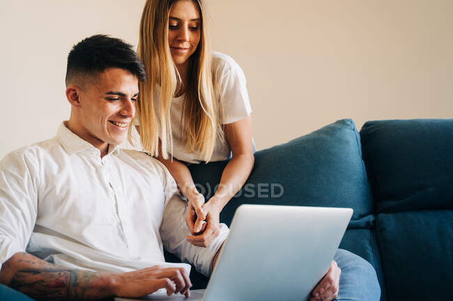 Couple romantique avec ordinateur portable sur le canapé — Photo de stock
