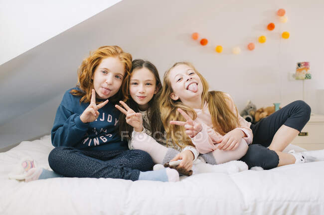 Fröhliche Kinder ruhen sich im Schlafzimmer auf dem Bett aus, während sie das Wochenende zusammen verbringen — Stockfoto