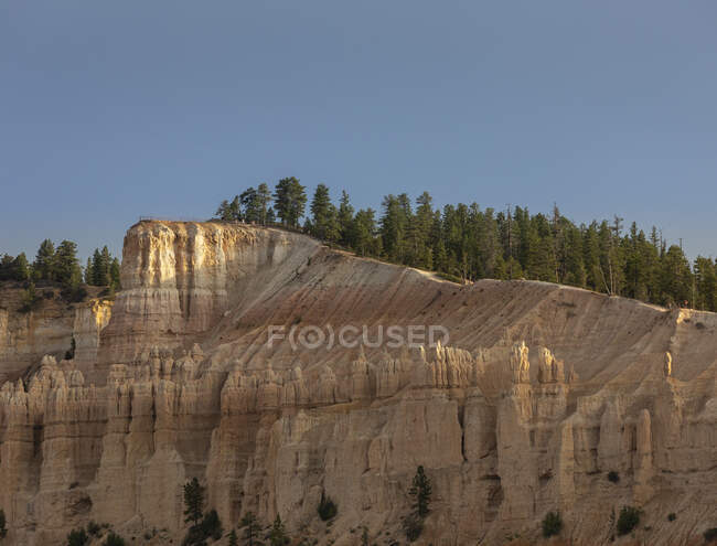 Paisagem pitoresca de altas formações rochosas com vegetação rara verde localizada em terreno deserto no desfiladeiro de Bryce com arenito nos EUA — Fotografia de Stock