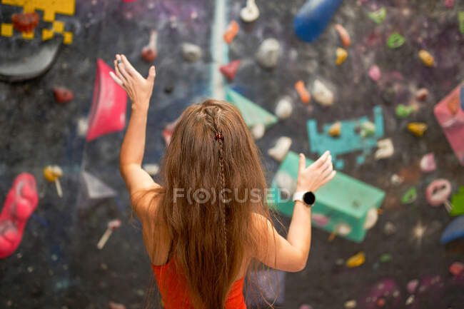 Back view strong woman in sportswear standing near climbing wall — Stock Photo