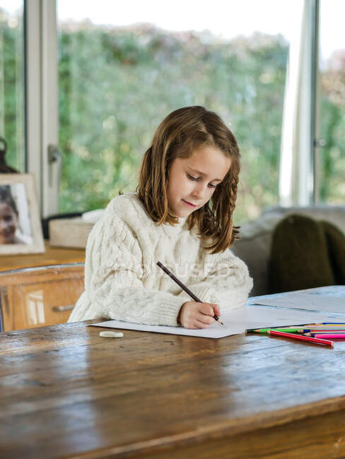 Schnitzen Sie kleine Mädchen Zeichnung mit Buntstiften auf Papier Blatt im hellen Raum — Stockfoto