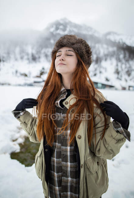 Jeune touriste consciente avec les yeux fermés respirant contre le mont pendant le voyage dans les Asturies en hiver — Photo de stock