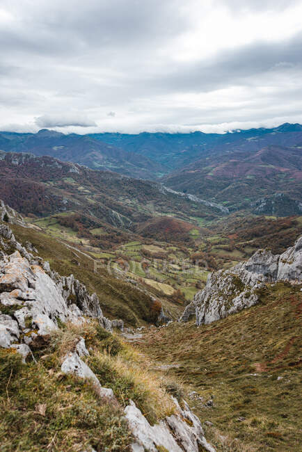 Picturesque scenery of vast rocky terrain covered with grass under cloudy sky in Asturias Spain — Stock Photo