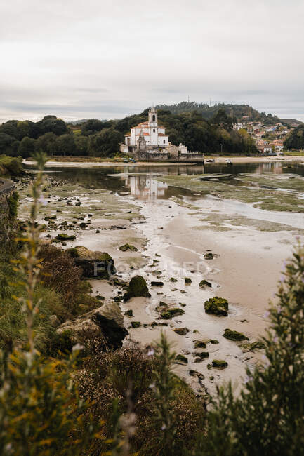 Paysage pittoresque de la paroisse blanche de Notre-Dame des Douleurs sur un rivage tranquille par temps couvert dans les Asturies Espagne — Photo de stock