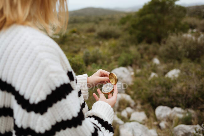 From above of crop anonymous female tourist using compass on mountain with rough stones in daylight — Fotografia de Stock