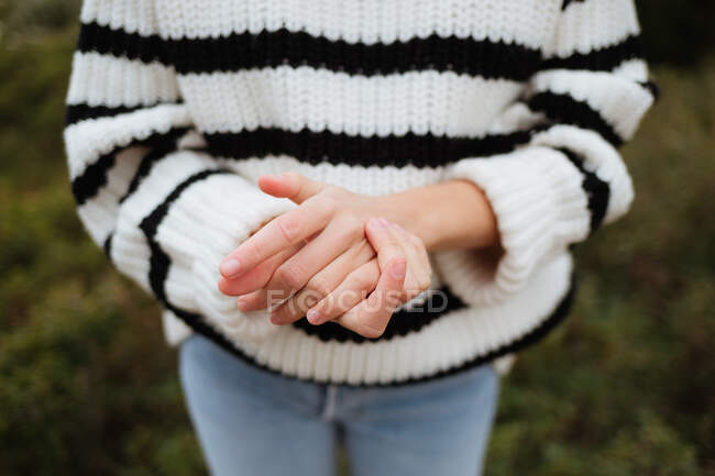 Culture touriste féminine anonyme en pull tricoté avec ornement montrant geste d'amitié sur la montagne en plein jour — Photo de stock