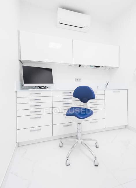 Stilvolles Interieur eines modernen hellen Klinikzimmers mit weißen Möbeln und blauem Stuhl — Stockfoto