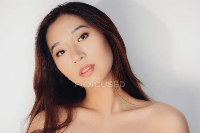 Портрет оголеної китайської жінки, що дивиться на фотоапарат на білому фоні. — стокове фото
