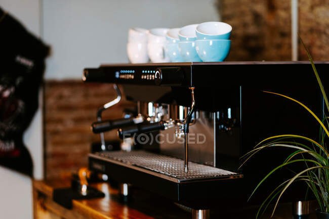 Glänzende Metallportafilter in zeitgenössischer Kaffeemaschine auf der Theke im Café platziert — Stockfoto