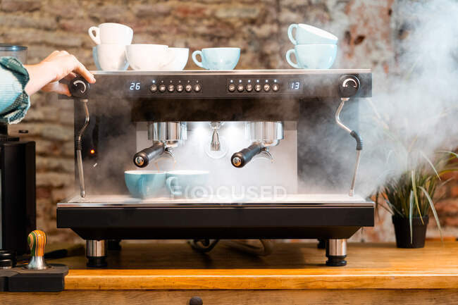 Кукурудза безликий бариста готує каву в кавоварці, розміщена на лічильнику в кафе в стилі лофт — стокове фото