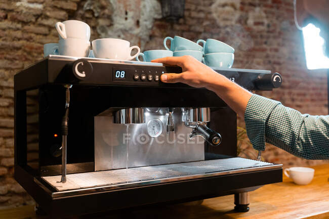 Неузнаваемый кукурузный бармен с портативным фильтром готовит напитки в современной кофеварке во время работы в кафе — стоковое фото