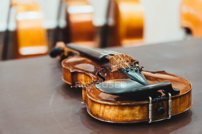 Dall'alto di violino lucente moderno messo su tavolo di legno squallido in workshop — Foto stock