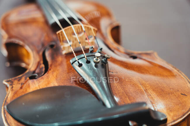 From above of modern shiny violin placed on shabby wooden table in workshop — Stock Photo