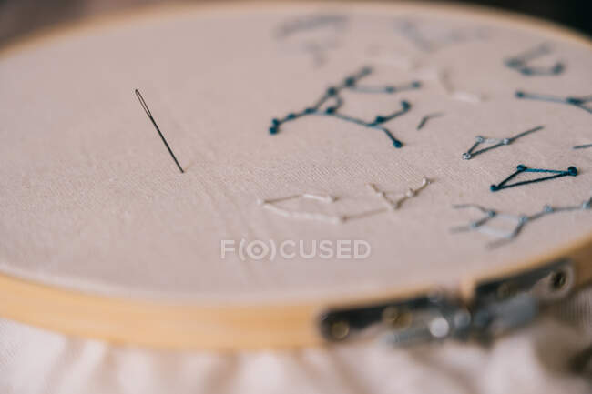 Embroidery of stars constellations weave on white fabric in hoop with sharp needle — Stock Photo