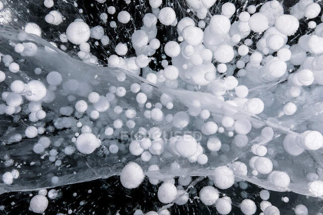 Vue du dessus des bulles de méthane gelées étonnantes sous l'eau du lac Baïkal glacé en hiver comme fond abstrait — Photo de stock