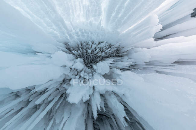 De baixo de enormes icicles pendurados em caverna rochosa perto do Lago Baikal no inverno como fundo abstrato — Fotografia de Stock