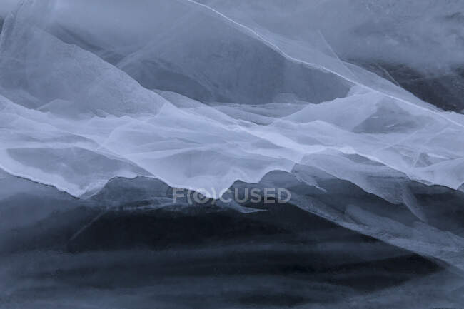 Вид сверху на ледяной абстрактный рисунок замёрзшего озера Байкал в пасмурный зимний день — стоковое фото