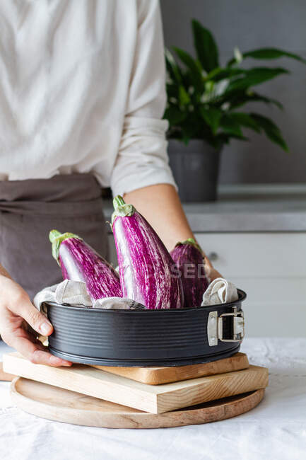 Cultivo persona anónima preparando verduras para cocinar almuerzo saludable en la cocina - foto de stock