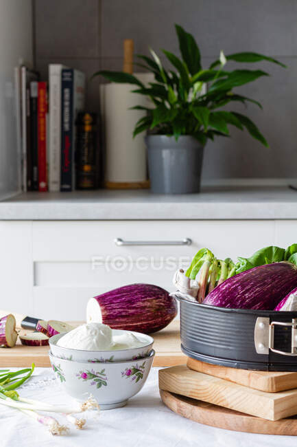 Schüssel Mozzarella mit grünen Zwiebeln und geschnittenen Auberginen auf Schneidebrett für ein gesundes Mittagessen — Stockfoto