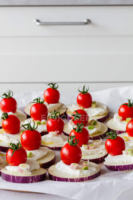 From above of yummy appetizers with fresh eggplants mozzarella whole cherry tomatoes olive oil and onion — Stock Photo