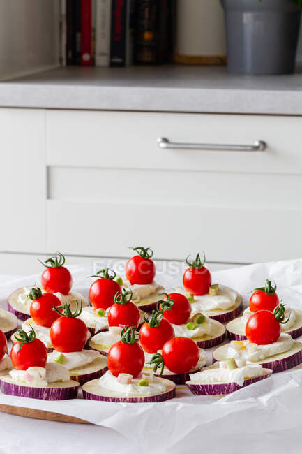 From above of yummy appetizers with fresh eggplants mozzarella whole cherry tomatoes olive oil and onion — Stock Photo