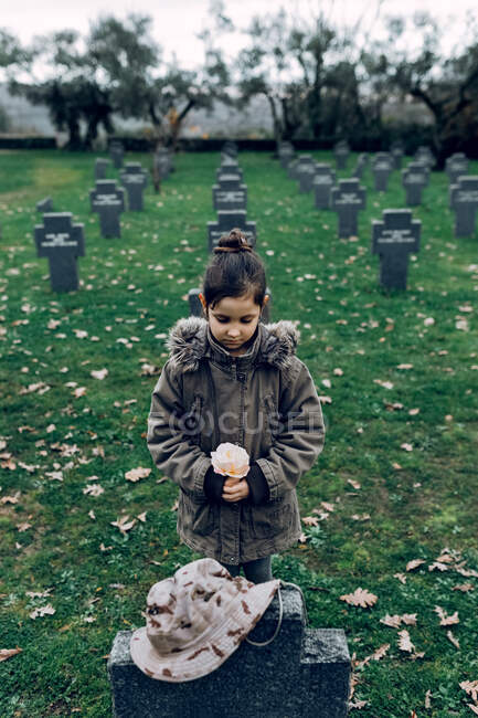 Ângulo alto de morte de luto de criança pequena de soldado que luta na guerra no cemitério — Fotografia de Stock