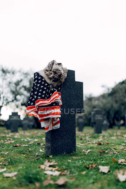 Государственный американский флаг и армейский флаг помещены на надгробии на военном кладбище в ранний осенний день — стоковое фото