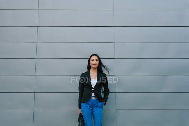 Auto fiducioso asiatico donna imprenditore in piedi sulla strada vicino edificio urbano e guardando la fotocamera — Foto stock