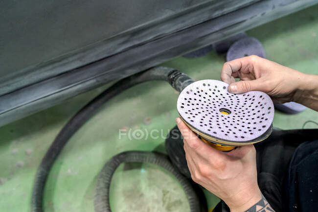 Сверху анонимного урожая мастер-мужчина с буферной машиной, готовящейся к полировке автомобиля в эксплуатации — стоковое фото