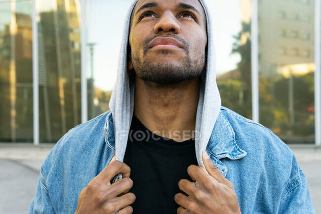 Adulto barbuto afroamericano maschio in abbigliamento casual in attesa in città alla luce del giorno — Foto stock