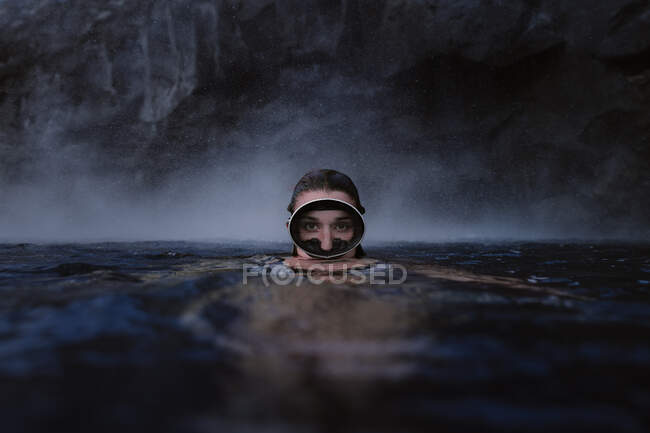 Mulher com óculos de mergulho no mar olhando para a câmera — Fotografia de Stock