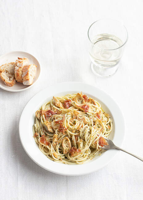 Крупним планом тарілку спагеті з артишоками, які видно зверху — стокове фото