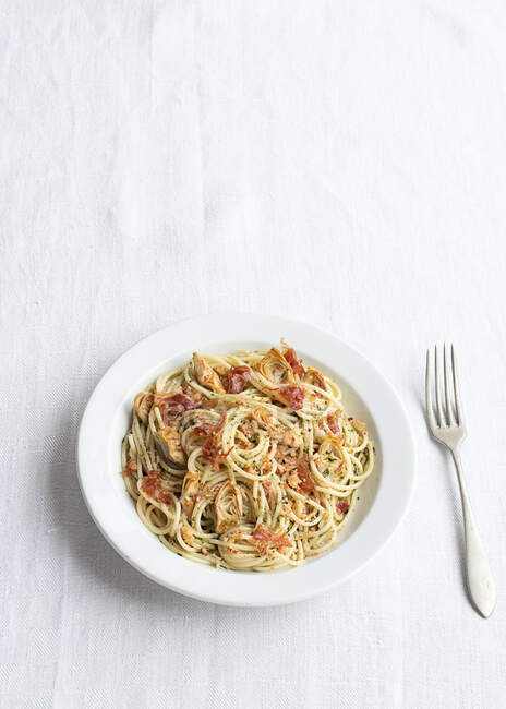 Primer plano de un plato de espaguetis con alcachofas visto desde arriba - foto de stock