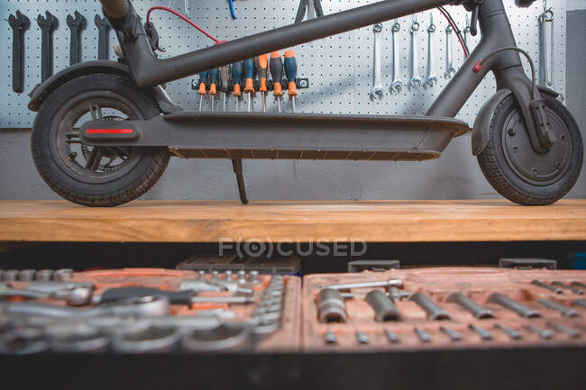 Старая коробка с отверткой и различными форсунками и ключами для автоматического обслуживания и ремонта на деревянном столе — стоковое фото