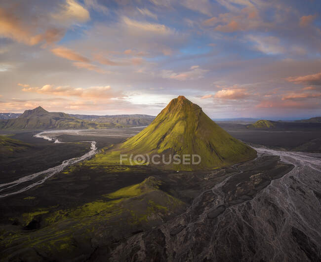 Increíble vista pacífica de terreno montañoso áspero cubierto de exuberante vegetación verde en el campo islandés - foto de stock