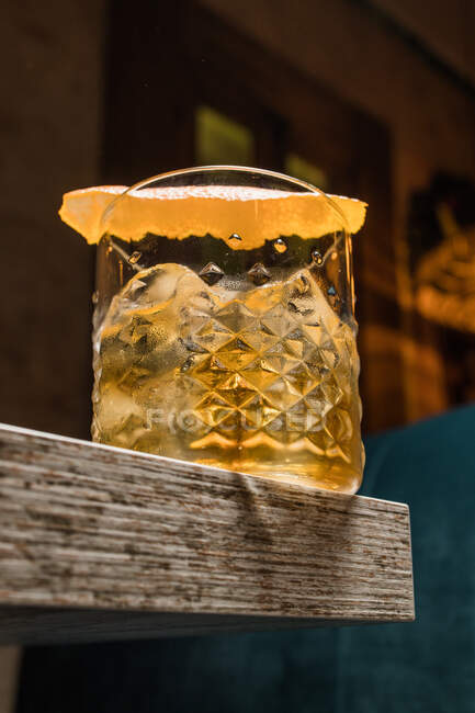 Tasse en verre Tiki avec boisson à l'ancienne placée sur la table sur fond flou — Photo de stock