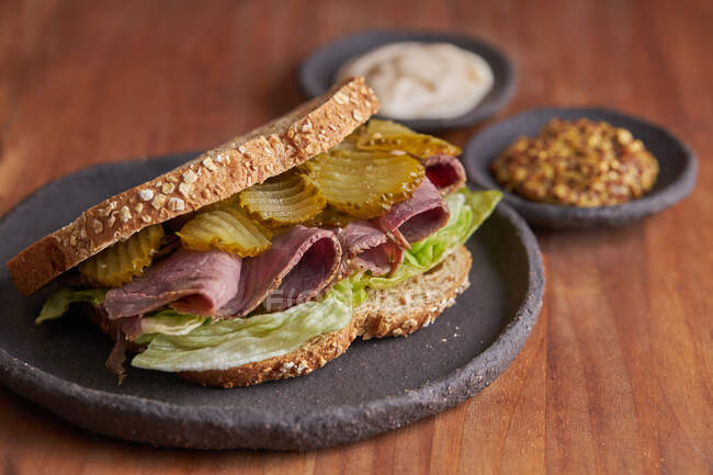 Closeup of a delicious pastrami, lettuce, ham and pickle sandwich — Stock Photo