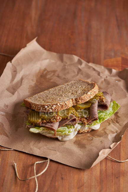 Closeup of a delicious pastrami, lettuce, ham and pickle sandwich — Stock Photo
