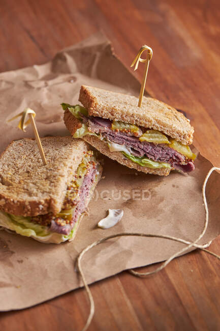 Gros plan d'un délicieux sandwich pastrami, laitue, jambon et cornichon — Photo de stock