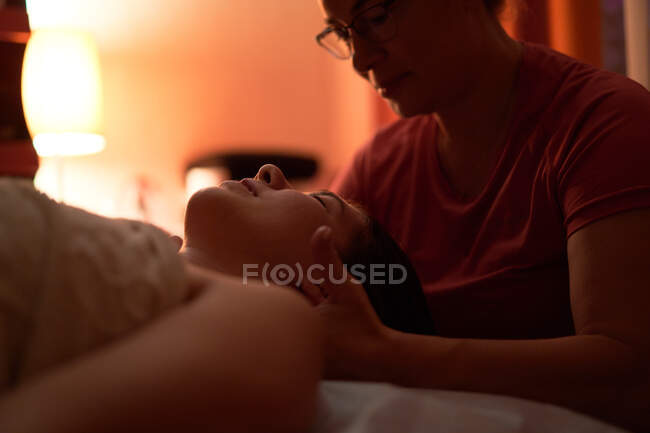 Cosecha masajista amasando hombros de la señora feliz durante la sesión de spa en el salón - foto de stock